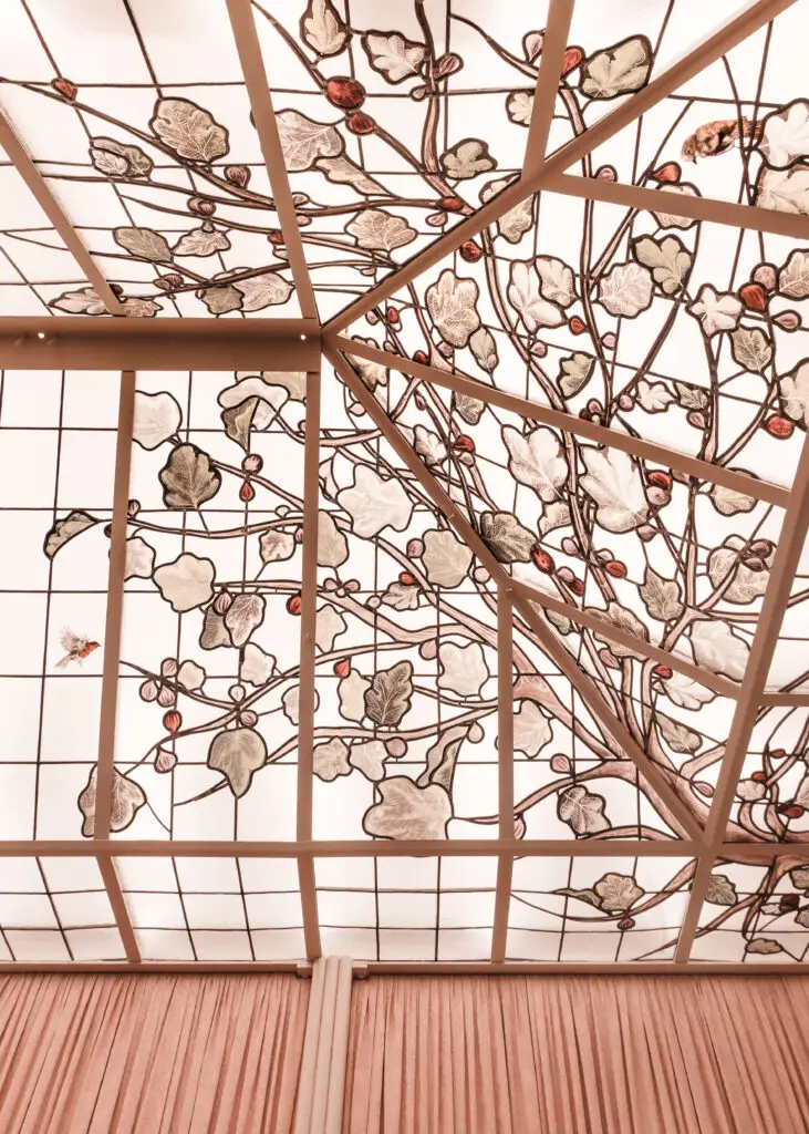 Oiseau peint sur verre parmi les feuillages du vitrail Grupomimo