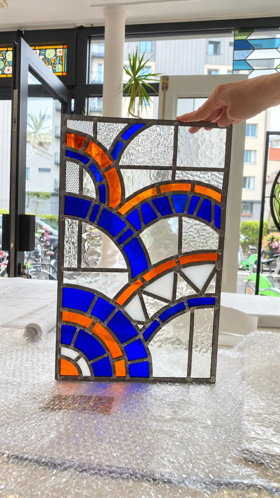 Panneau de vitrail art déco aux courbes bleues et orange sur fond de verres incolores texturés